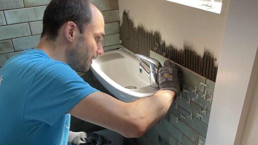 Chris heroically tiling a wall